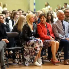 Uczestnicy sali, w tym nauczyciele, siedzą w pierwszym rzędzie, słuchając uważnie. To ważna rada pedagogiczna.
