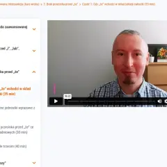 Mężczyzna w kratę tłumaczy, kiedy postawić przecinek przed "że", omawiając jego użycie w składzie jakiejś całości.