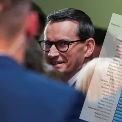 Premier Polski w okularach, obok wykres z danymi o deficycie budżetowym krajów UE.