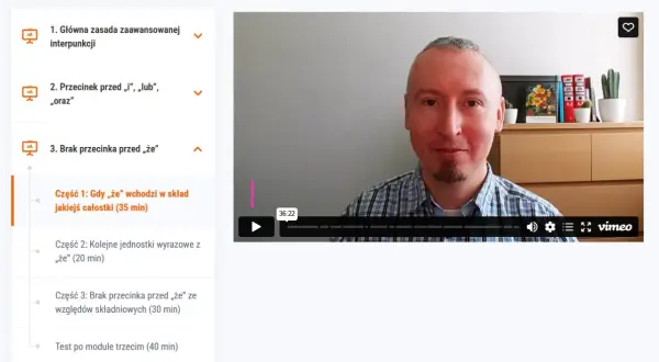Mężczyzna w kratę tłumaczy, kiedy postawić przecinek przed "że", omawiając jego użycie w składzie jakiejś całości.