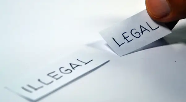 Kciuk przesuwa kartkę z napisem "LEGAL", obok leży kartka z napisem "ILLEGAL". Czy to było niedawno, czy nie dawno?